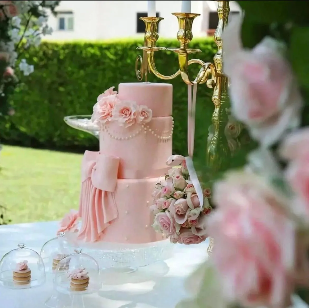 Torta rosa a più piani esposta nel giardino della villa